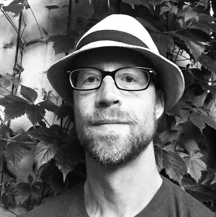 portrait of Hamilton-based Canadian writer and photographer Jeff Hayward who is wearing a hat and glasses