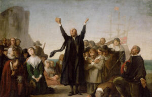 Puritan early Americans in a group praising the lord God in prayer carrying a bible with ships and a rock face in the background