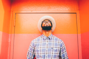 Portrait of rapper Charlie Smarts standing in front of orange wall