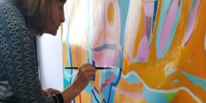 Artist Chrissy Guest working on a large abstract picture in her studio
