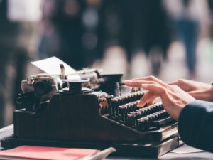 person on typewriter outside reading flash fiction
